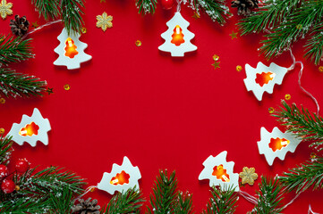 White Christmas trees with fir branches on a red background Christmas background with space for text.