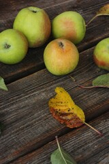 Green apples and autumn leaves on the table