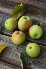 Green apples and autumn leaves on the table