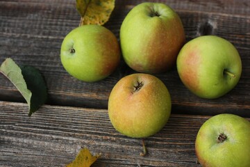 Green apples and autumn leaves on the table