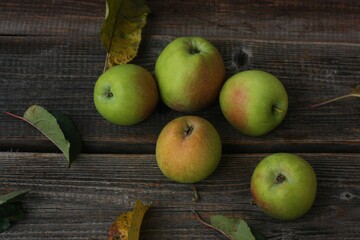 Green apples and autumn leaves on the table