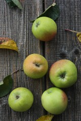 Green apples and autumn leaves on the table