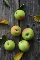 Green apples and autumn leaves on the table