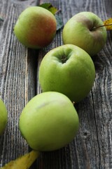 Green apples and autumn leaves on the table