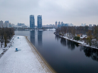 Aerial drone view. Snow-covered city beach in the Kiev. A thin layer of the first snow on the sand.