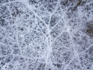 Aerial drone view. Snow-covered roads in the park. A thin layer of the first snow on earth.