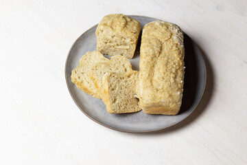 Plate with homemade oat bread on white background