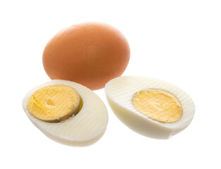 Two boiled eggs, one cut in half .