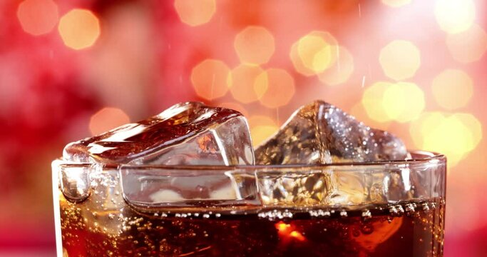 Glass of cola. Ice cola with splashing bubbles slow motion on a blurry light ,blurry background.