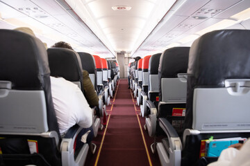 Airplane Aisle  with the Passengers Sitting on their Seats