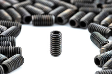 Background made from a macro shot of one standing, black grub screw on white table.