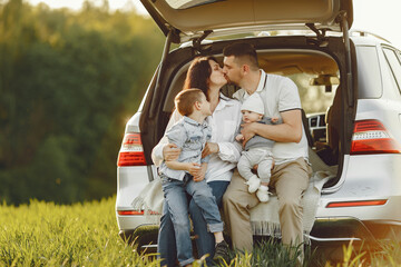 Family in a forest. People by the car. Sunset background.