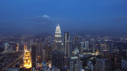 Obraz premium Petronas Towers, colorful vibrant twilight after sunset. Panoramic night scene of Kuala Lumpur, Malaysia, Asia. Image is ideal for background. Toned image.