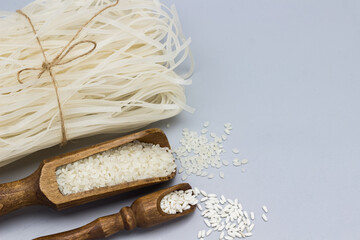 Two types of white rice in wooden scoops. Rice noodles