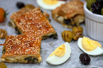Burekas. Puff pastry pies with spinach with spinach, salted cheese, and sesame