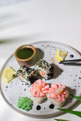 Sushi rolls on light background with leafs