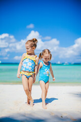 Fototapeta na wymiar Adorable little girls having fun on the beach