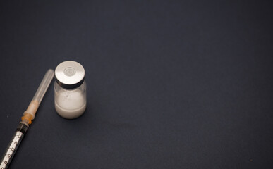 vaccine bottle with syringe, and blue background