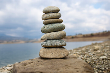 Fototapeta na wymiar Perfect gravel balance on the seashore. Balance, harmony and meditation concept. Aiding or supporting someone to grow or rise.