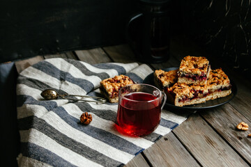 shortcrust pastry pie with black currants and tea on a dark background