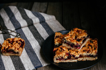 shortcrust pastry pie with black currants and tea on a dark background