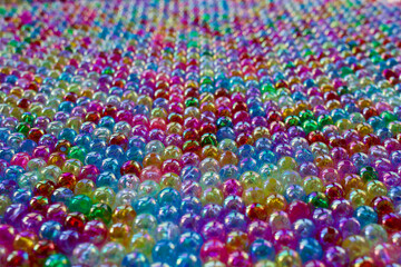 Fototapeta na wymiar Set of transparent, shiny and many-coloured beads looking like soap bubbles. Seed beads for use in necklaces and bracelets.