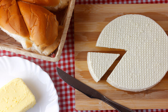 fresh white brazilian minas cheese isolated over wooden board on breakfast table