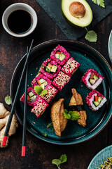 Delicious rolls, sushi and maki on a dark wooden Board with chopsticks. On black rustic background