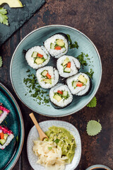 Delicious rolls, sushi and maki on a dark wooden Board with chopsticks. On black rustic background