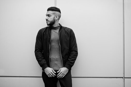 Portrait of stylish arab beard man wear grey turtleneck and black jaket. Arabian model guy against steel wall.