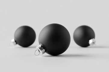 Three black matte Christmas balls mockup on a seamless grey background.
