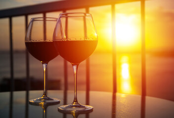 Two glasses with red wine in sunset