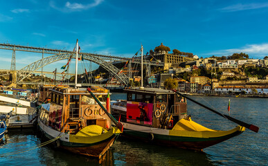 Fototapeta na wymiar Tourist boats moored up on the Douro river by the Dom Luiz bridge in Porto, Portugal on a sunny afternoon