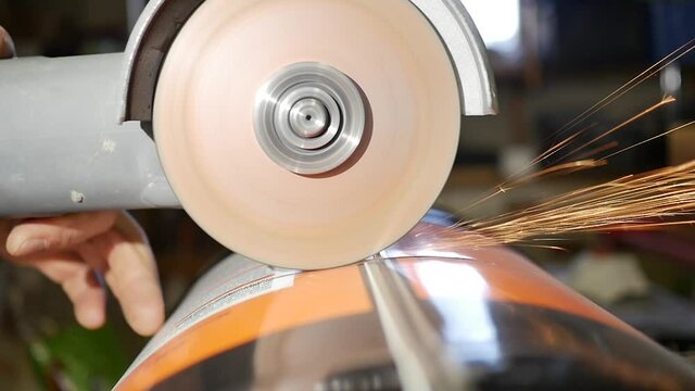 professional angle grinder grinding metal canister. DYI recycling projet for the house, metalwork and metal art with abrasives and flap disc on scrap metal using grinder tools.
