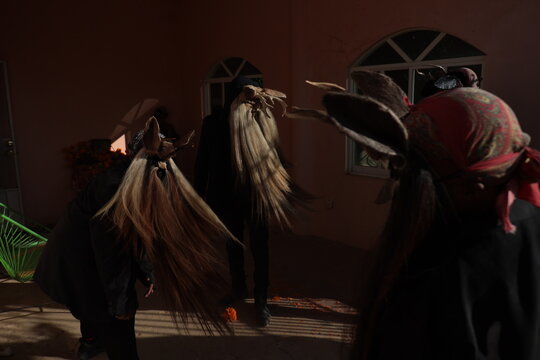 Dancers performing the dance of the black devils outside the pantheon on October 31, 2020 in Cuajinicuilapa, Guerrero, Mexico where it is believed that devils attract souls
