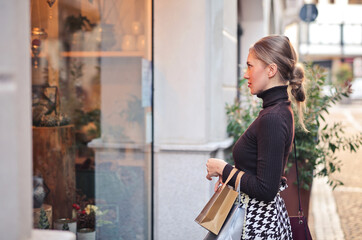 young woman in the city in front of a shop window