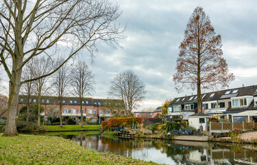 Beautiful park in Waterland in Spijkenisse, the Netherlands, lake, reflection on water, houses and tree