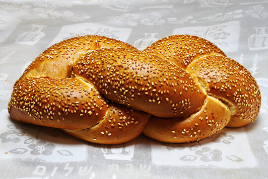 Challah -  Jewish Bread, traditionally baked to celebrate the Shabbat. The inscriptions on the tablecloth translated from Hebrew means Shabbat Shalom (peaceful Saturday), Jewish holiday, Israel