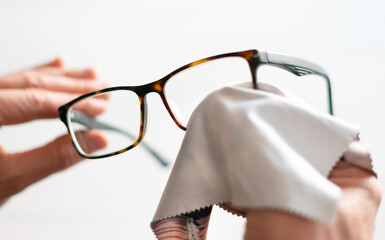 Cleaning glasses. A man wipes his glasses with a cloth. Selective focus.