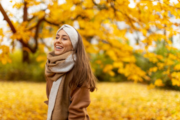 Portrait of smiling young woman in a park in autumn
