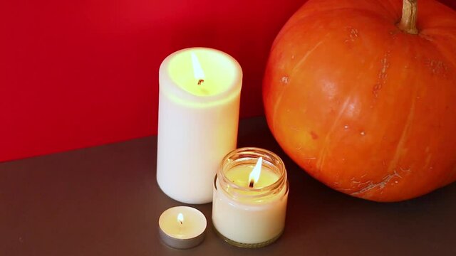 lighted candles with pumpking on table. Halloween atmosphere, decoration