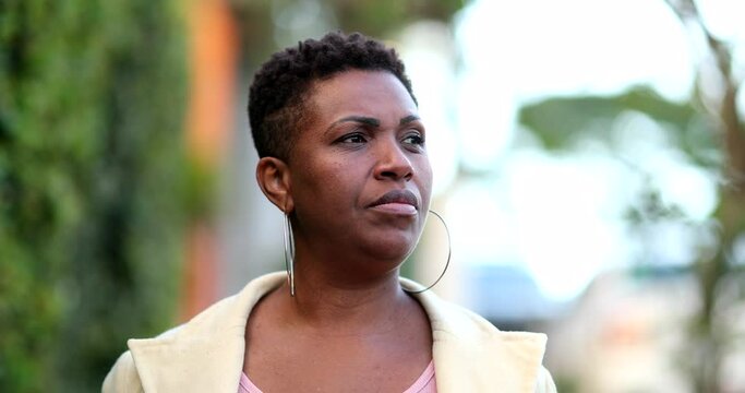Confident serious African woman 40s walking towards camera in street