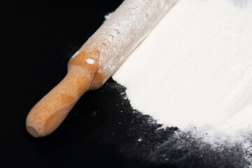 In the upper-right corner of the screen on a dark surface is a hill of white flour. The rolling pin is located diagonally.