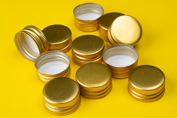 Metal bottle caps on a yellow background.