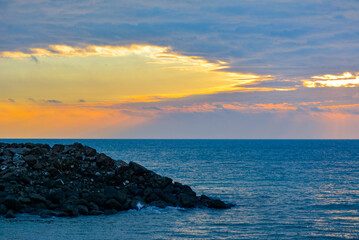 Atardecer en la playa con contraste de rocas