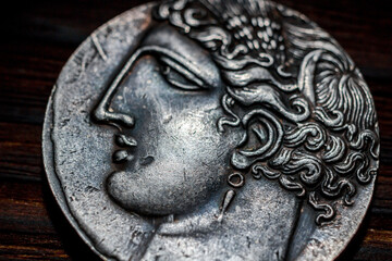 Souvenir Greek coin with the image of the face of the ancient Greek close-up. Copy of an old greek coin drachma - obrazy, fototapety, plakaty