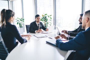 Corporate employees sitting at meeting table having conference brainstorming for discussing business ideas and create startup strategy for progressive project, concept of briefing for search solutions