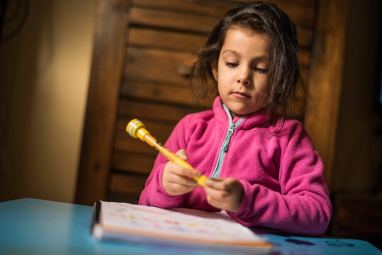 Little girl drawing and doing homerworks at home