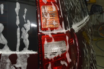 The car body is covered with soap suds to remove dirt. Car wash
