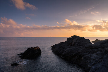 Obraz premium Beautiful cloudy sunrise from a cliff in Cabo de Palos with the sun reflected in the sea water, Murcia, Spain